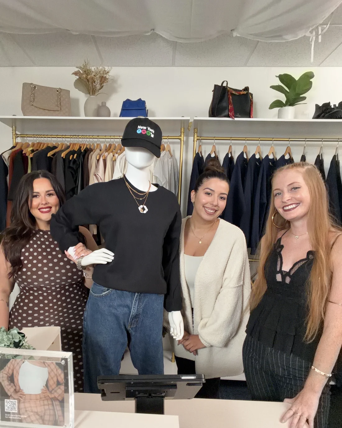 Three Teamwork Commerce team members at the counter of an apparel store, beside the point of sale