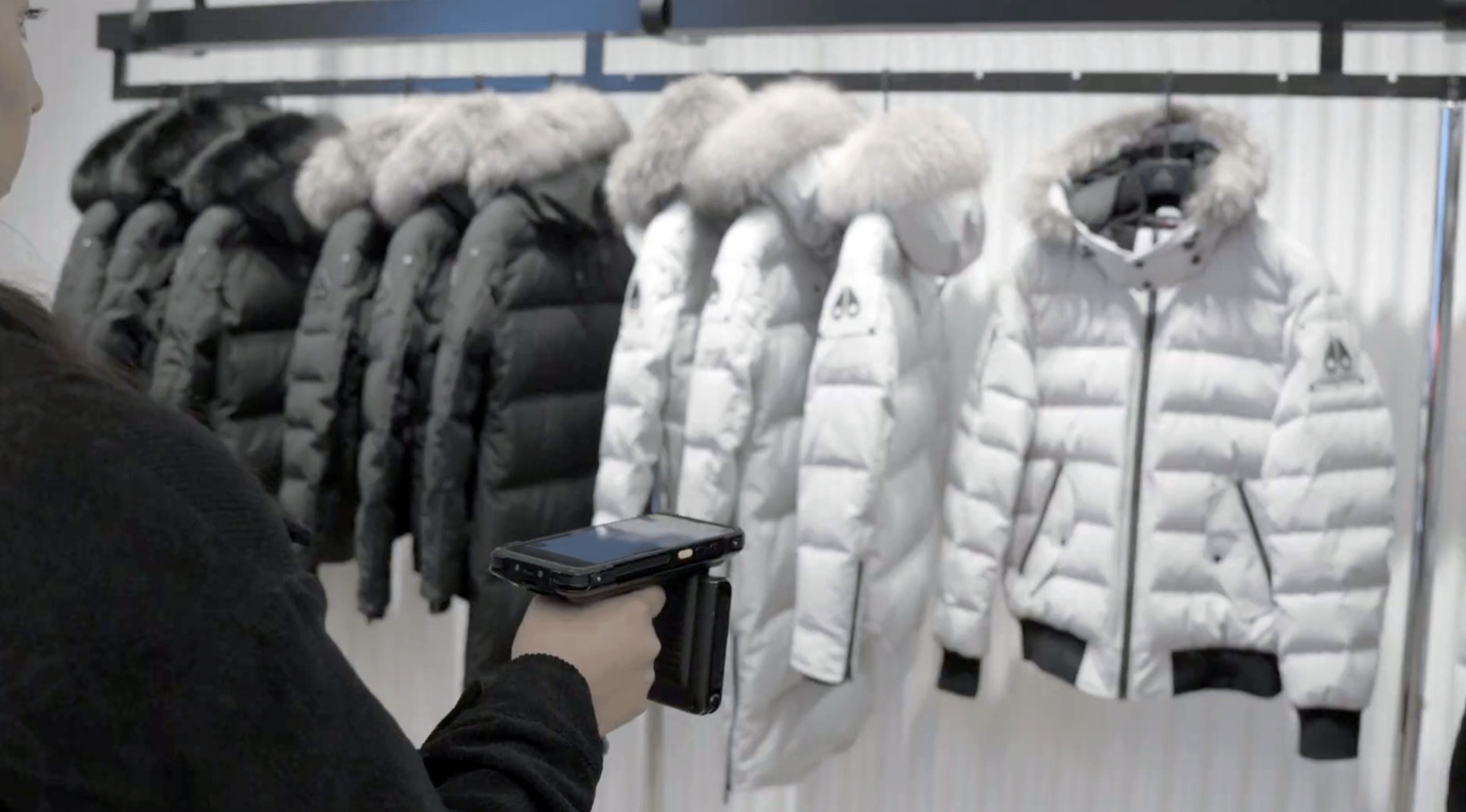 An associate sweeping a rack of jackets with an RFID handheld